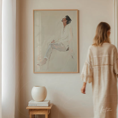 quadro em estilo minimalista com retrato de mulher sentada em moldura clara, exibido em parede neutra