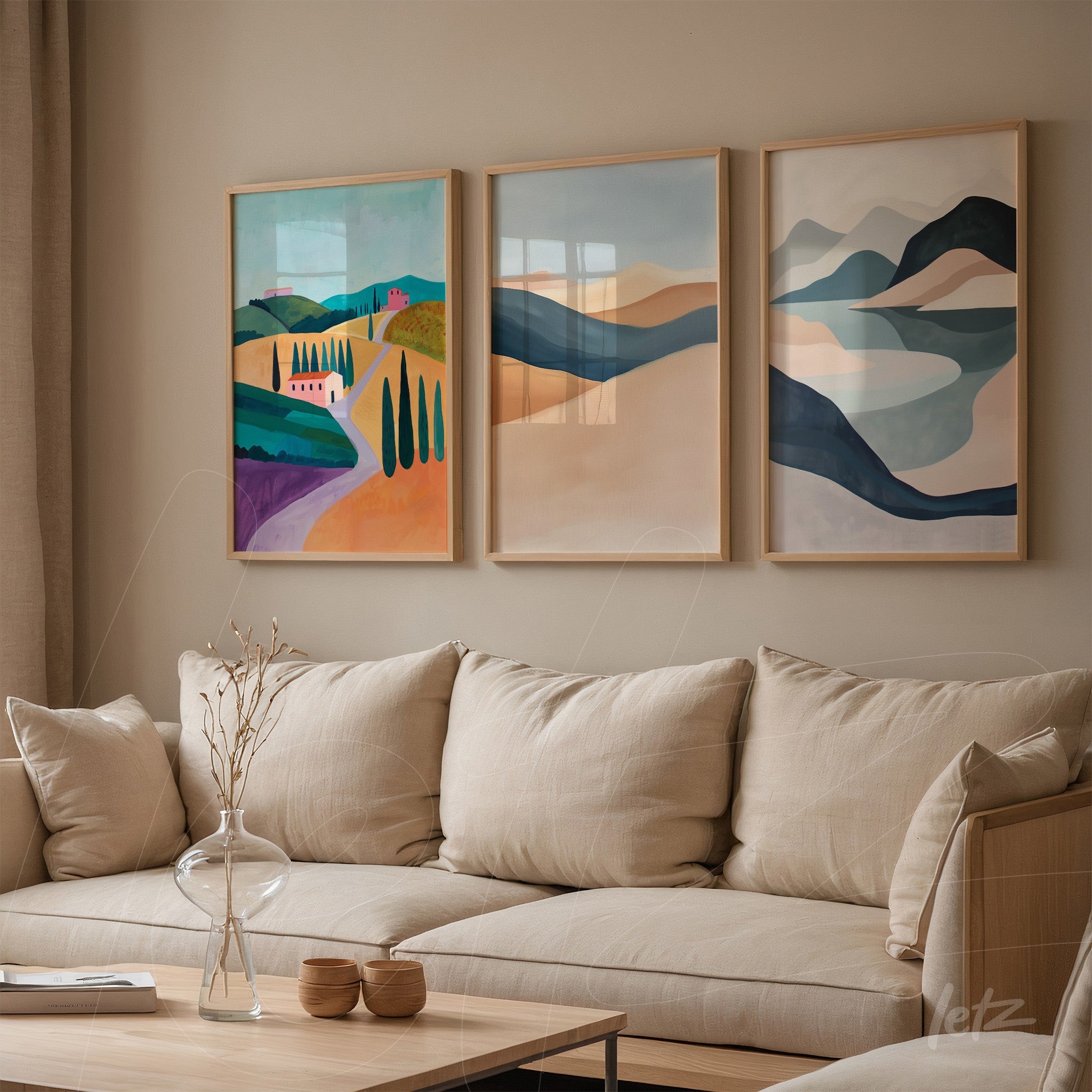 composição de três quadros com paisagens coloridas em molduras de madeira clara, destacados sobre parede bege ao lado de sofá em tecido neutro