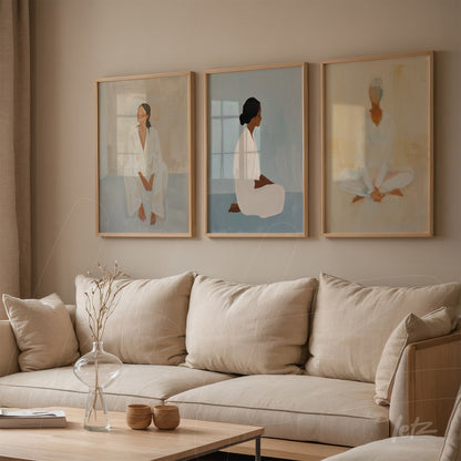 composição de três quadros com mulheres retratadas em estilo minimalista, molduras de madeira clara, expostos em parede neutra ao lado de sofá de linho