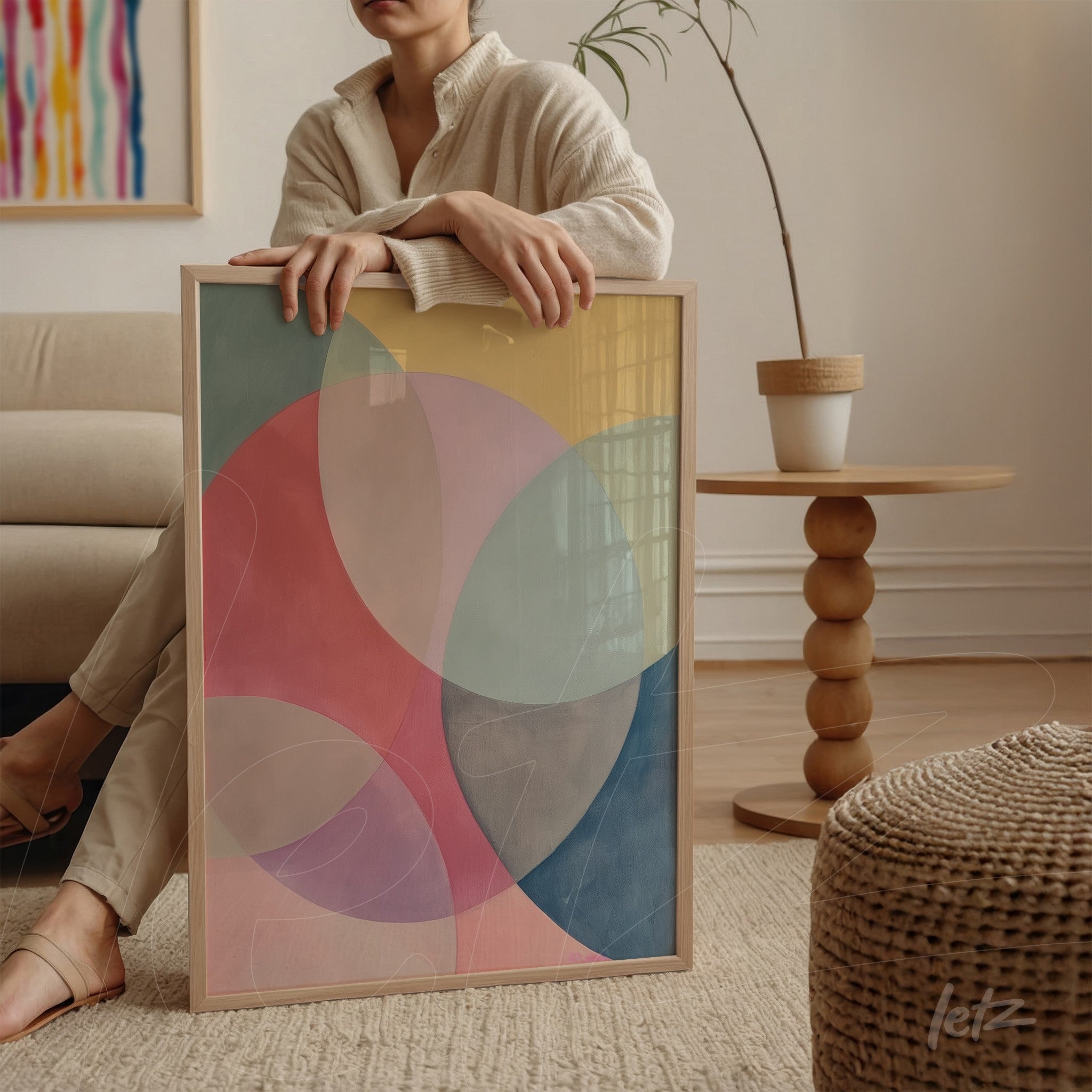 quadro com arte abstrata em cores suaves dentro de moldura de madeira clara exibido em ambiente minimalista