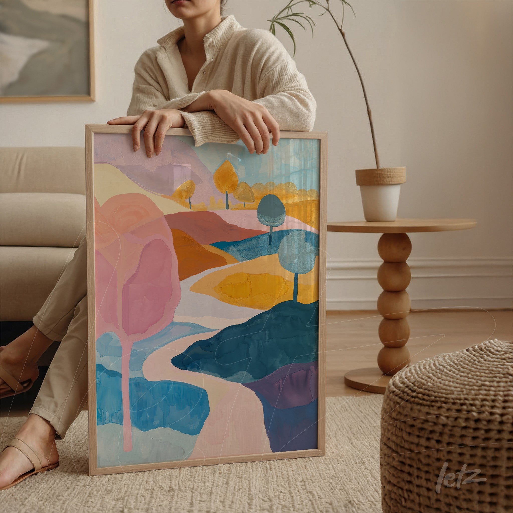 quadro com arte abstrata de paisagem em moldura clara, apresentando cores suaves como rosa, azul e amarelo com árvores estilizadas