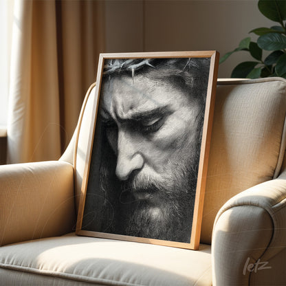 quadro em moldura de madeira clara com retrato em preto e branco de uma figura masculina com coroa de espinhos, em close