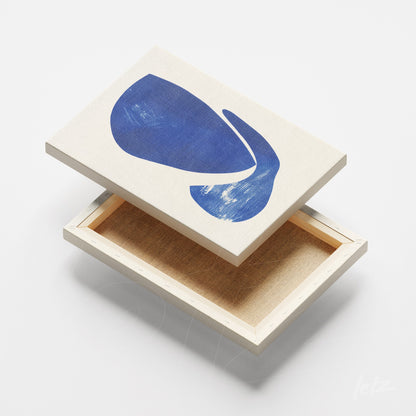 canvas com arte abstrata em azul sobre fundo claro com moldura de madeira