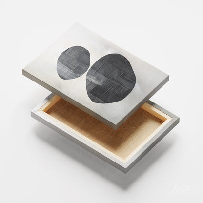 tela em canvas com arte abstrata em tons neutros, destacando formas ovais em preto sobre fundo texturizado