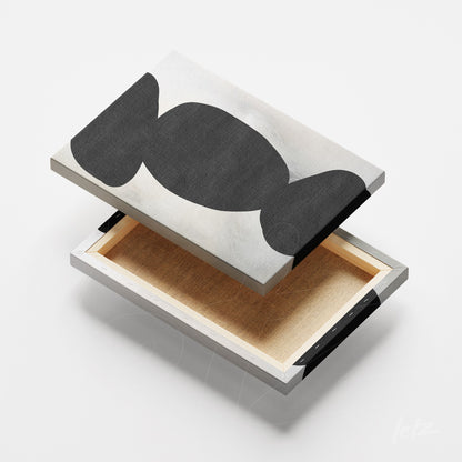 detalhe de quadro em canvas com design abstrato em preto e branco, mostrando a moldura metálica