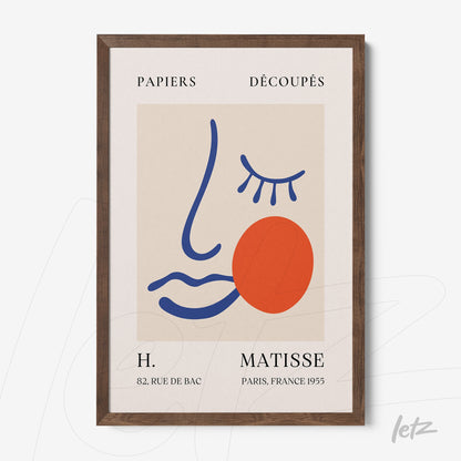 quadro emoldurado com arte abstrata de rosto estilizado em tons de azul, laranja e vermelho sobre fundo neutro