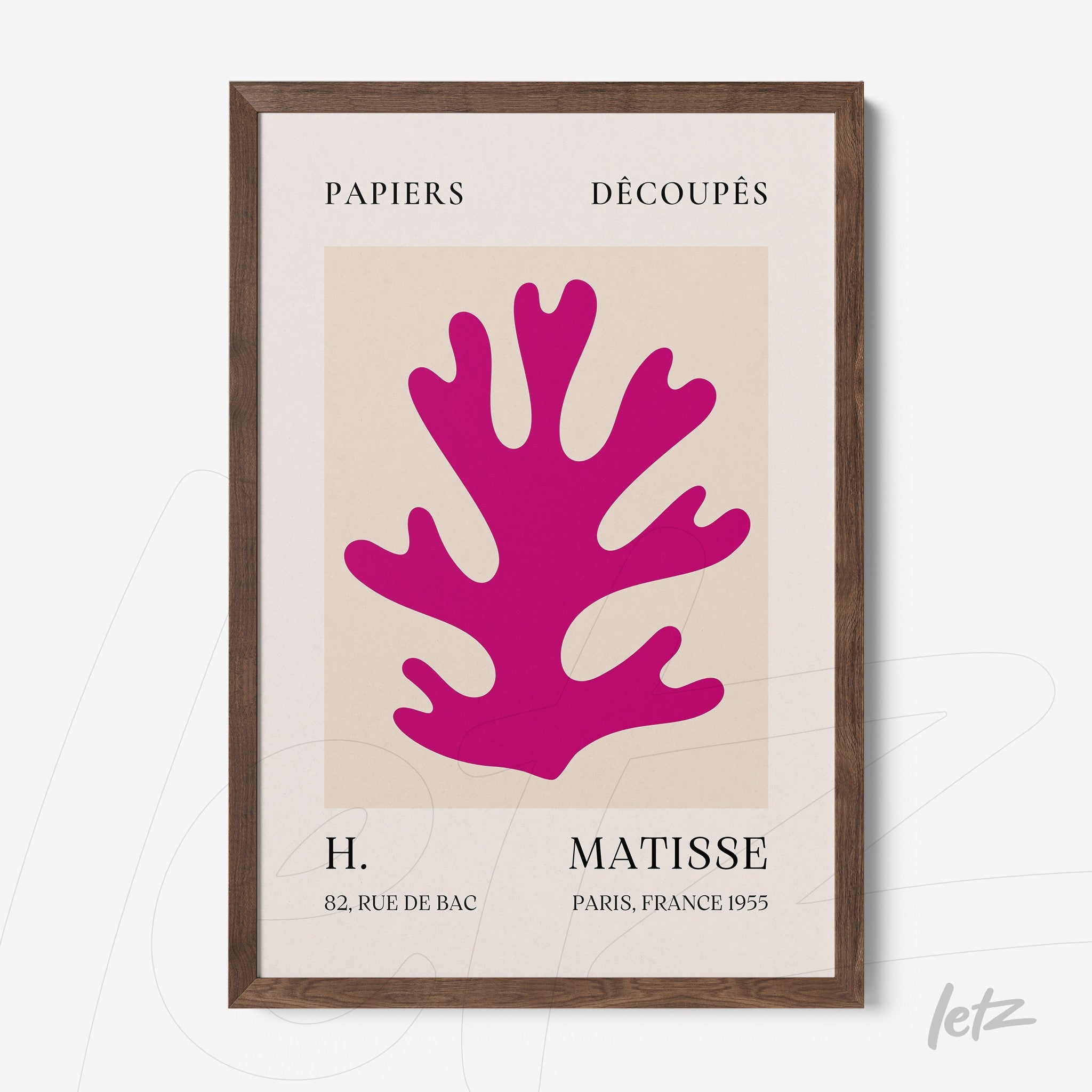 quadro em moldura de madeira clara com arte de papel recortado em cor rosa vibrante sobre fundo neutro