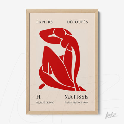 quadro com arte recortada de forma feminina em vermelho sobre fundo bege, moldura de madeira clara