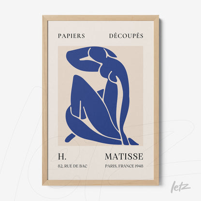 quadro decorativo com arte modernista em azul de figura feminina em posição sentada, com moldura de madeira clara