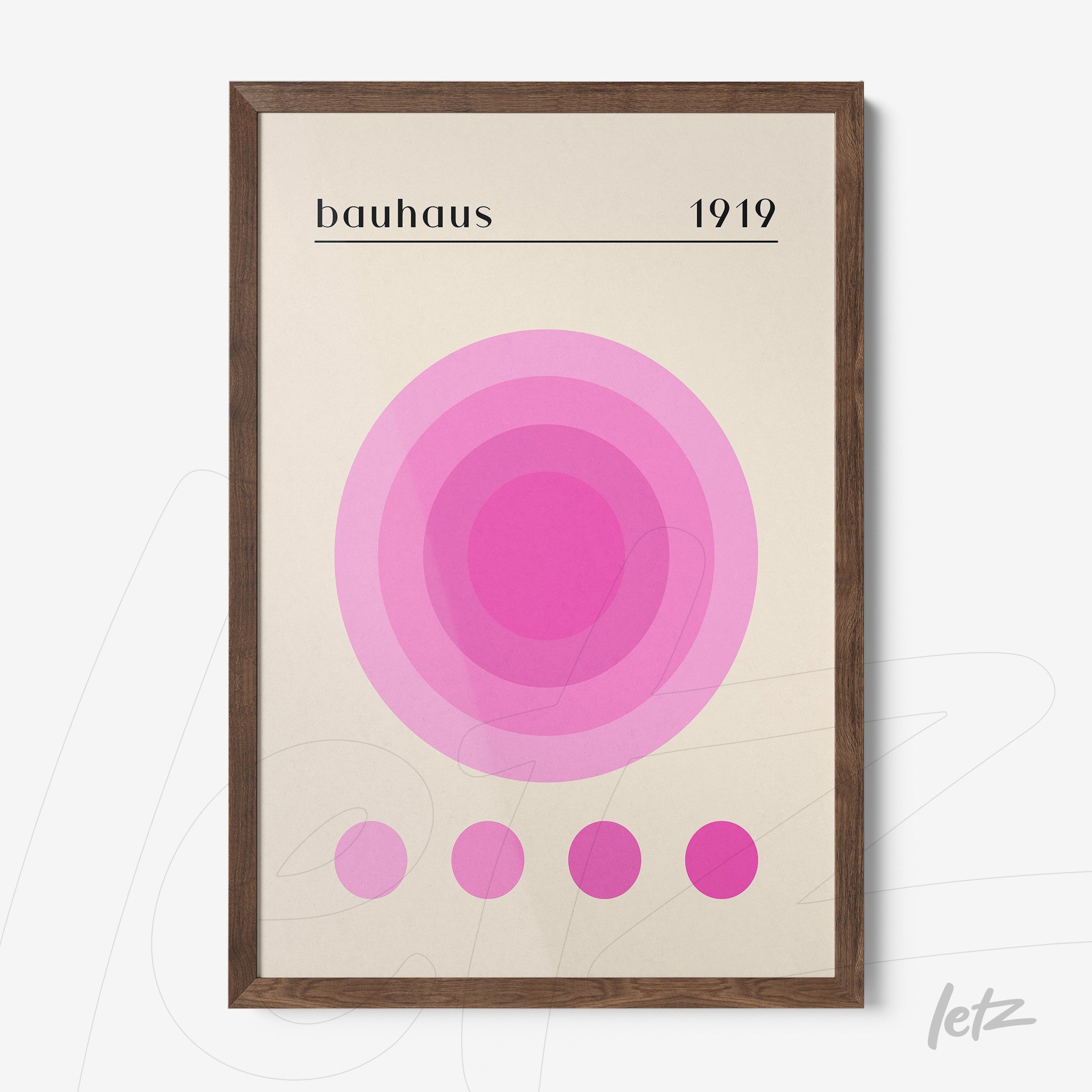 pôster impresso com círculos concêntricos em tons de rosa sobre fundo claro emoldurado em madeira escura