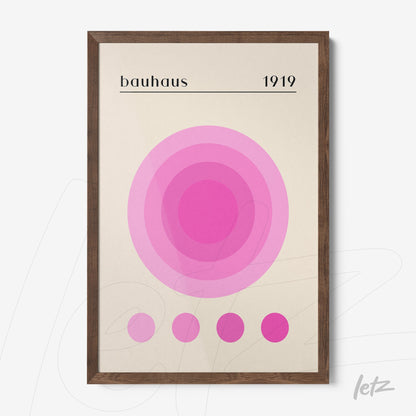 pôster impresso com círculos concêntricos em tons de rosa sobre fundo claro emoldurado em madeira escura