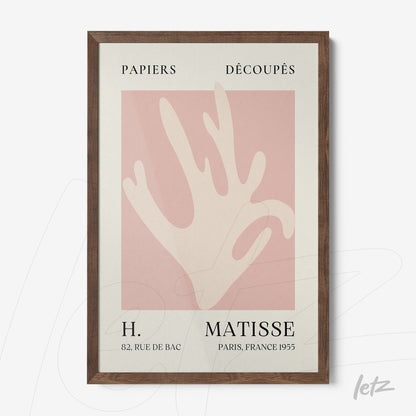 quadro com arte moderna de recortes em papel em fundo rosa e moldura de madeira escura