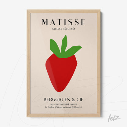 quadro com arte estilizada de morango em cores vibrantes, moldura de madeira clara e fundo neutro