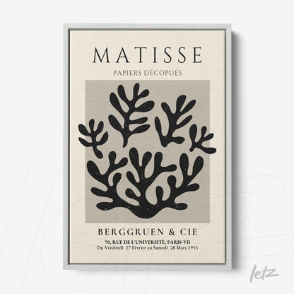 quadro com arte de recortes em papel em preto sobre fundo claro, com moldura prata e título em destaque