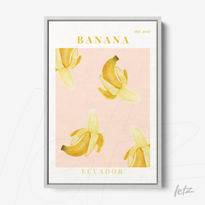 quadro com ilustrações de bananas em amarelo sobre fundo rosa, moldura prateada e texto estilizado em amarelo