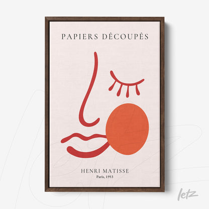 quadro com arte abstrata de rosto em vermelho e terracota, escrito PAPIERS DÉCOUPÉS, moldura de madeira escura