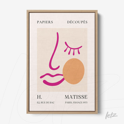 quadro com arte moderna abstrata em moldura de madeira clara, apresentando um rosto simples em linhas coloridas e formas geométricas