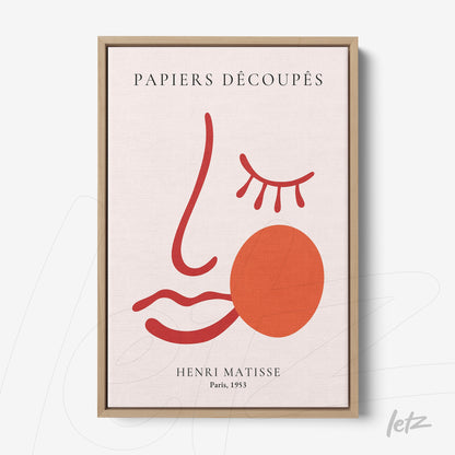 quadro com arte moderna de perfil estilizado em tons vermelhos e rosa, moldura de madeira clara