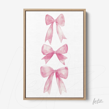 quadro em canvas com ilustrações de laços rosa em fundo branco, moldura de madeira clara