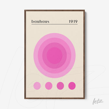 quadro com círculos concêntricos em tons de rosa com texto bauhaus 1919 em moldura de madeira
