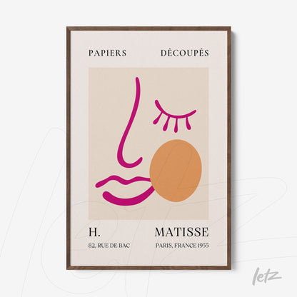 quadro com arte minimalista em fundo claro, apresentando traços em rosa e laranja que formam um rosto estilizado, moldura de madeira escura