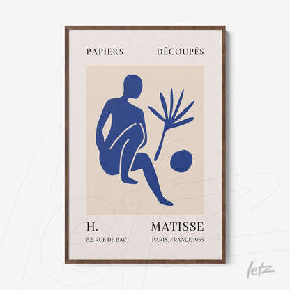 quadro com arte estilizada em azul mostrando uma figura humana sentada ao lado de uma planta e uma bola, moldura marrom escura