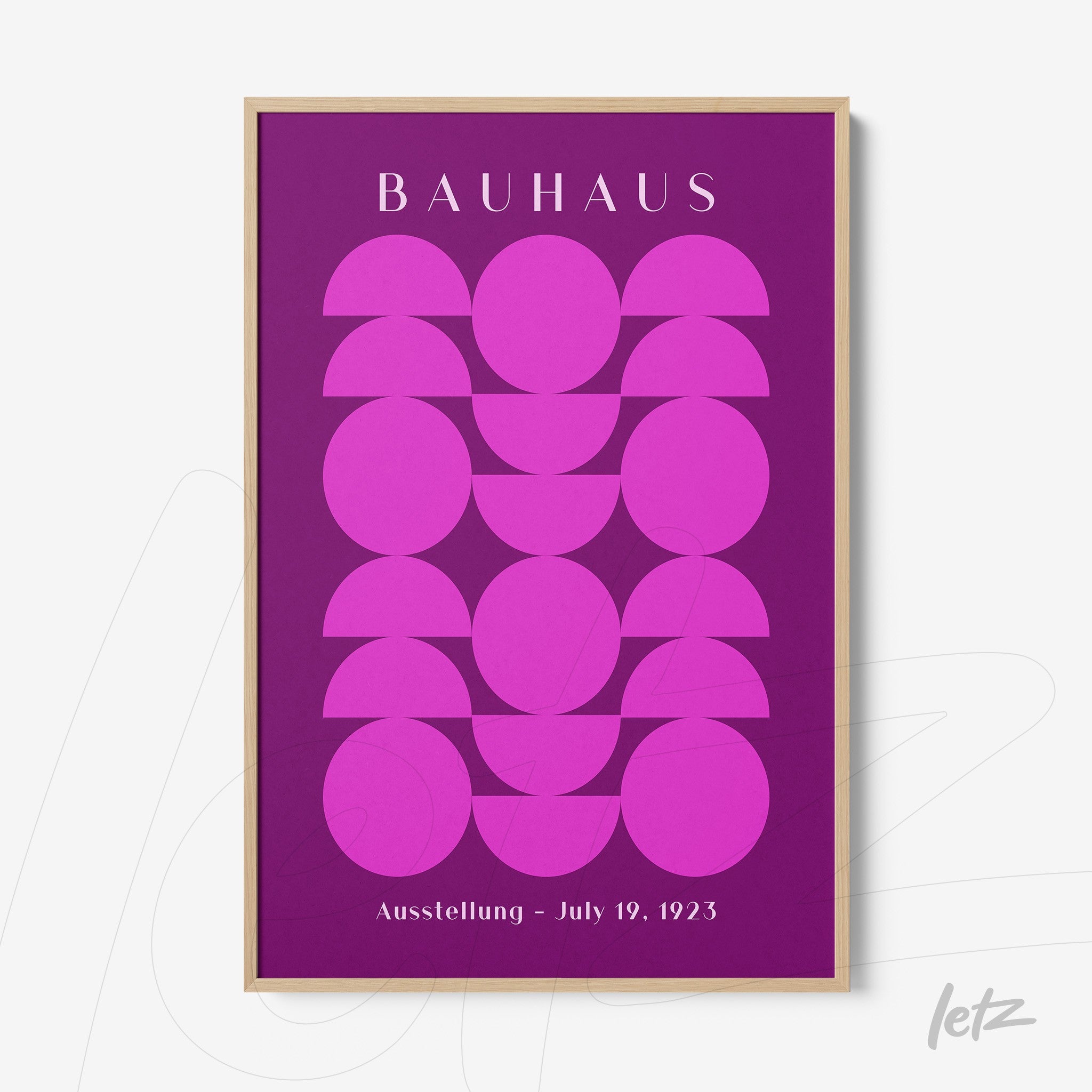 pôster impresso de arte geométrica com formas circulares em rosa sobre fundo roxo, emoldurado em madeira clara