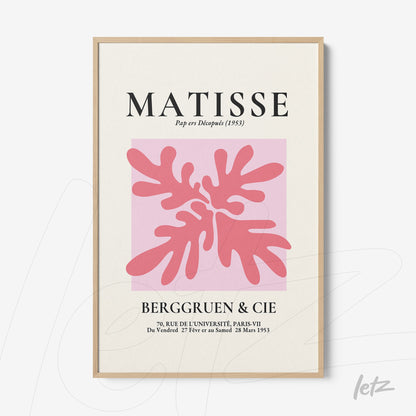 quadro com arte modernista em tons de rosa e vermelho, com moldura de madeira clara e fundo rosa suave