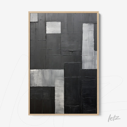 quadro abstrato com composição geométrica em tons de preto, cinza e branco, moldura de madeira clara