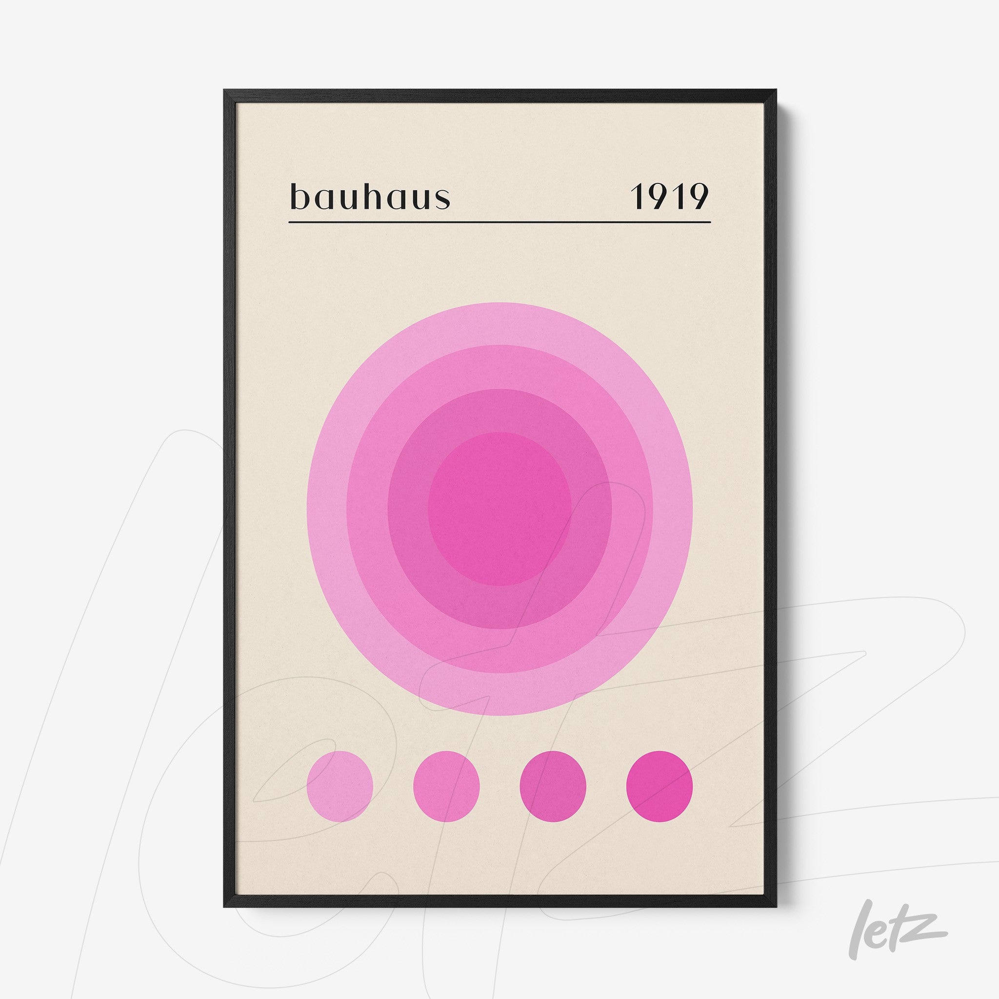 pôster com círculos concêntricos em tons de rosa com texto 'bauhaus 1919' em moldura preta exibido sobre parede branca