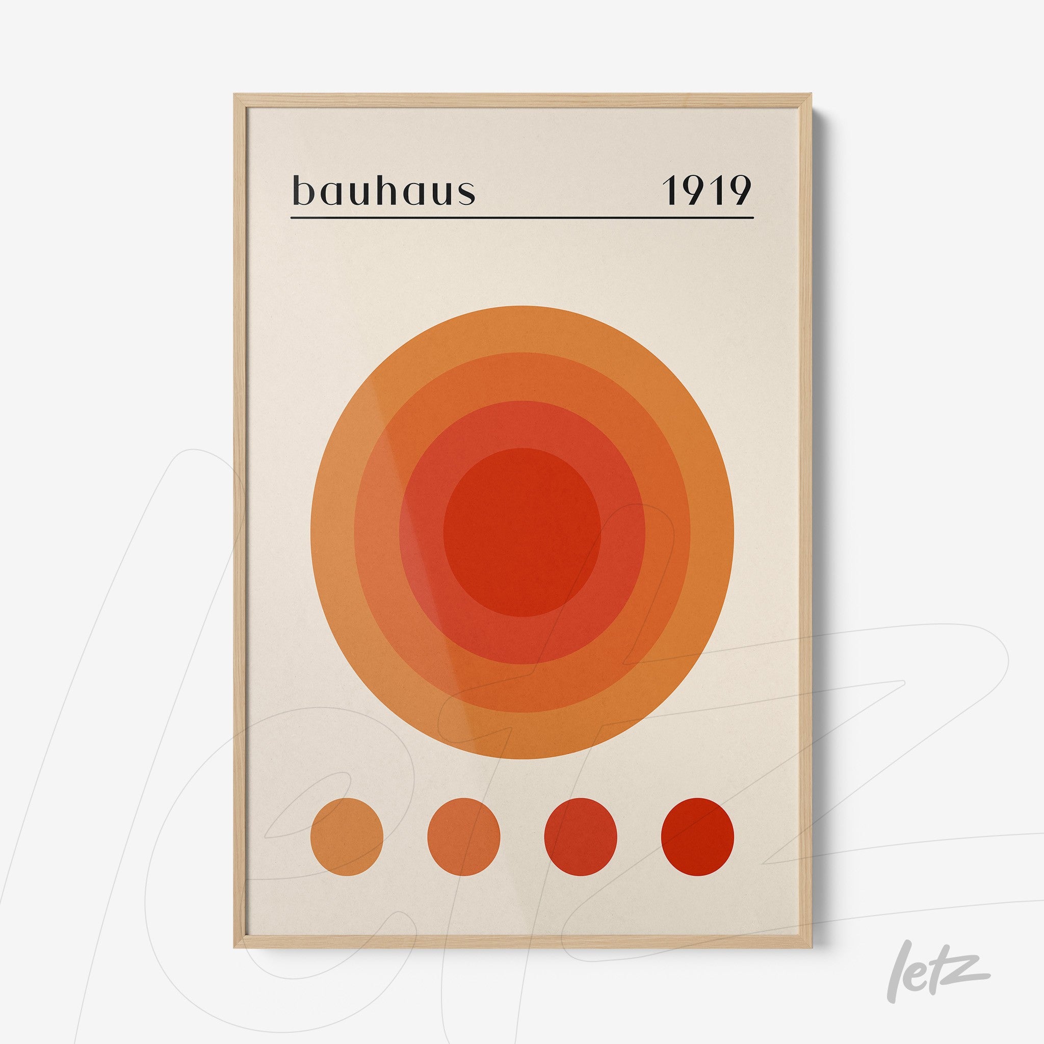 pôster impresso com círculos concêntricos em tons de laranja e vermelho com a palavra bauhaus 1919 exposta em moldura de madeira clara