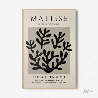 quadro com arte abstrata de recortes em preto, com moldura de madeira clara e fundo creme